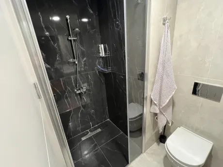 Стильная ванная комната с современным дизайном, качественной керамической плиткой и просторной душевой зоной.